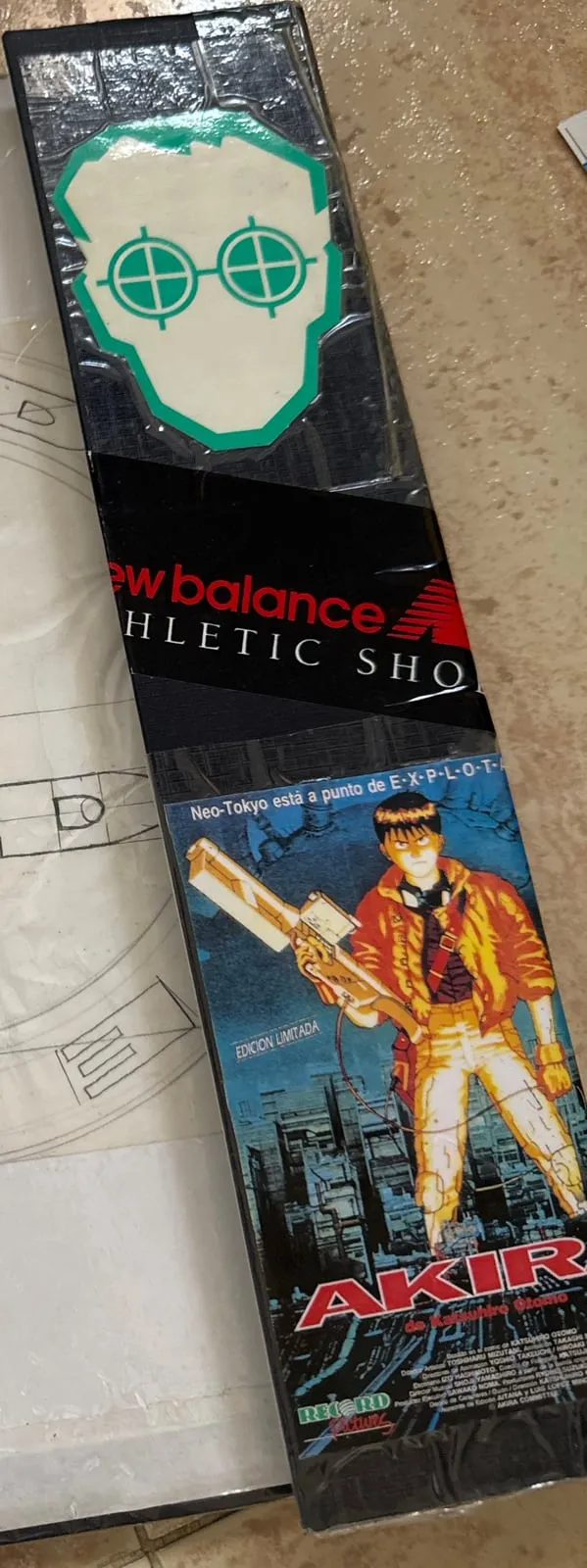 Lomo de la carpeta con una pegatina de una cara con gafas de mira, una de New Balance y la carátula del vídeo de Akira con Kaneda.