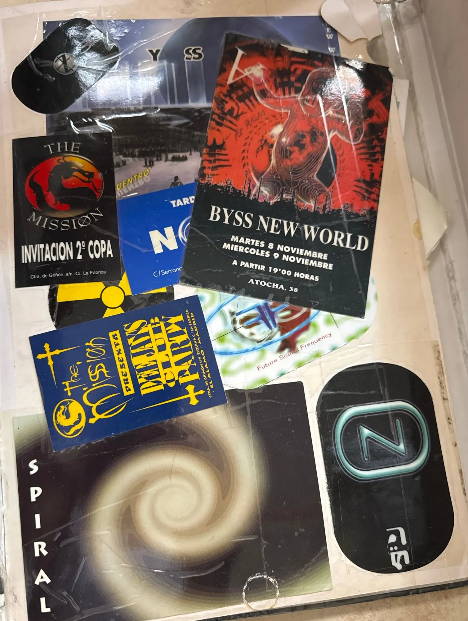 Página interior con invitaciones de The Mission y de Abyss New World, y pegatinas de Now, Spiral y Future Sound Frequency.